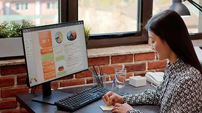 Young lady working on a desktop, making notes