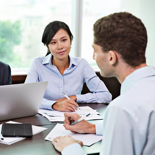 People having a meeting and making notes in a board room