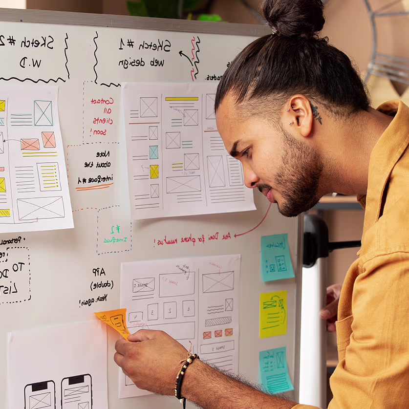 Young man pasting sticky page on a notice board