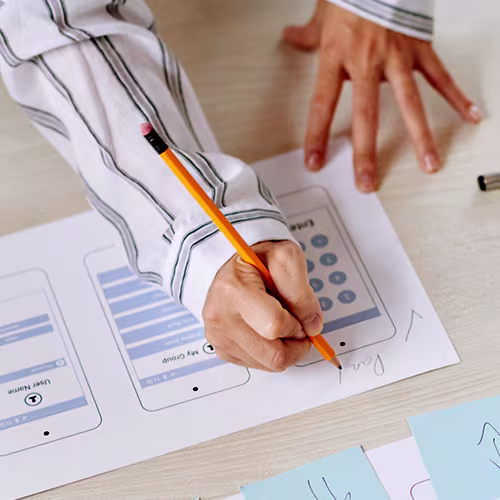 Person using a pencil to make notes on a chart with mobile elements